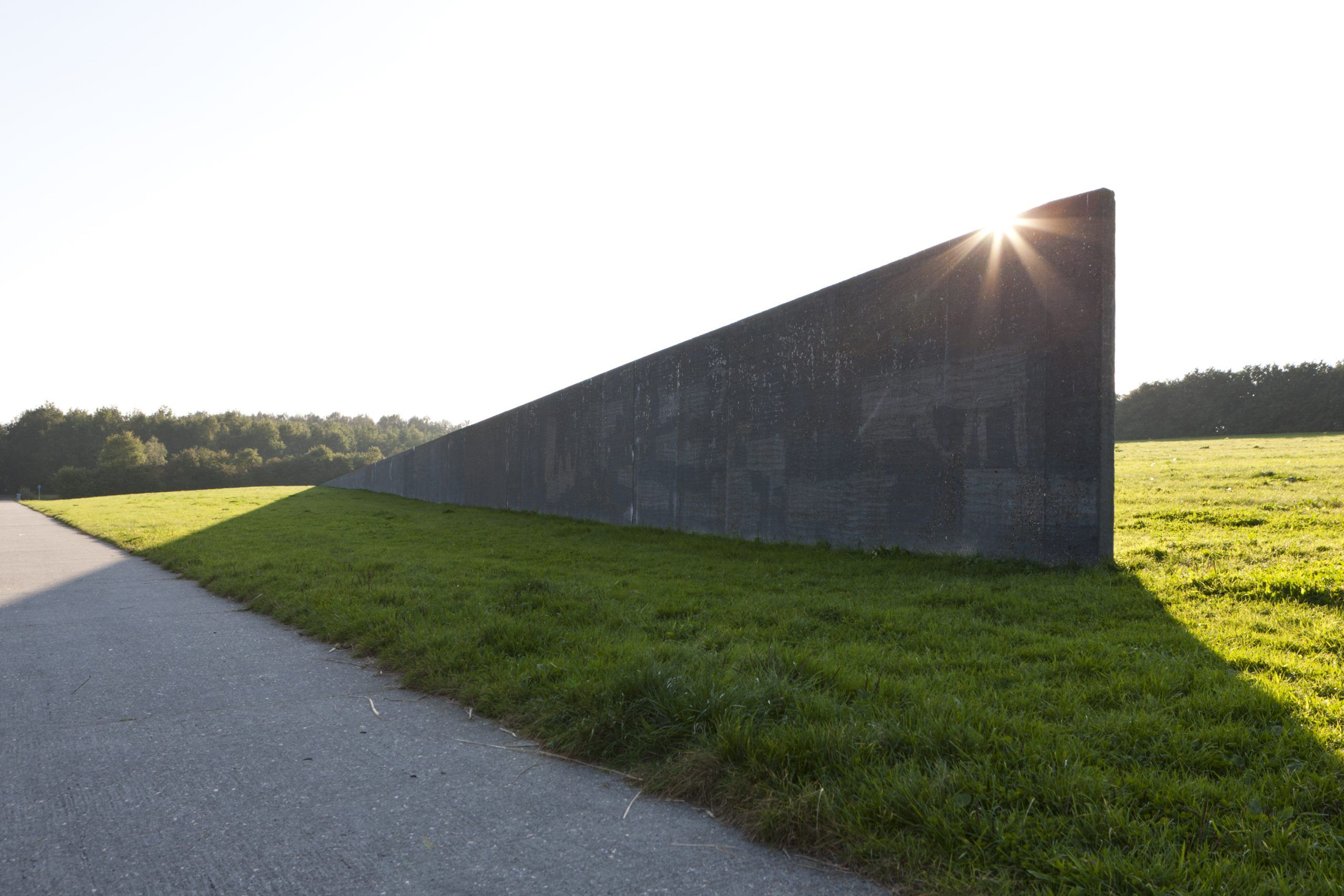 landschapskunstwerk in Flevoland. betonnen muur in graslandschap dat het niveau van water voorsteld
