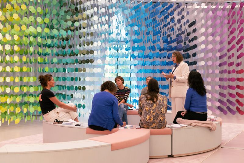 groep vrouwen in gesprek voor kleurrijk kunstwerk